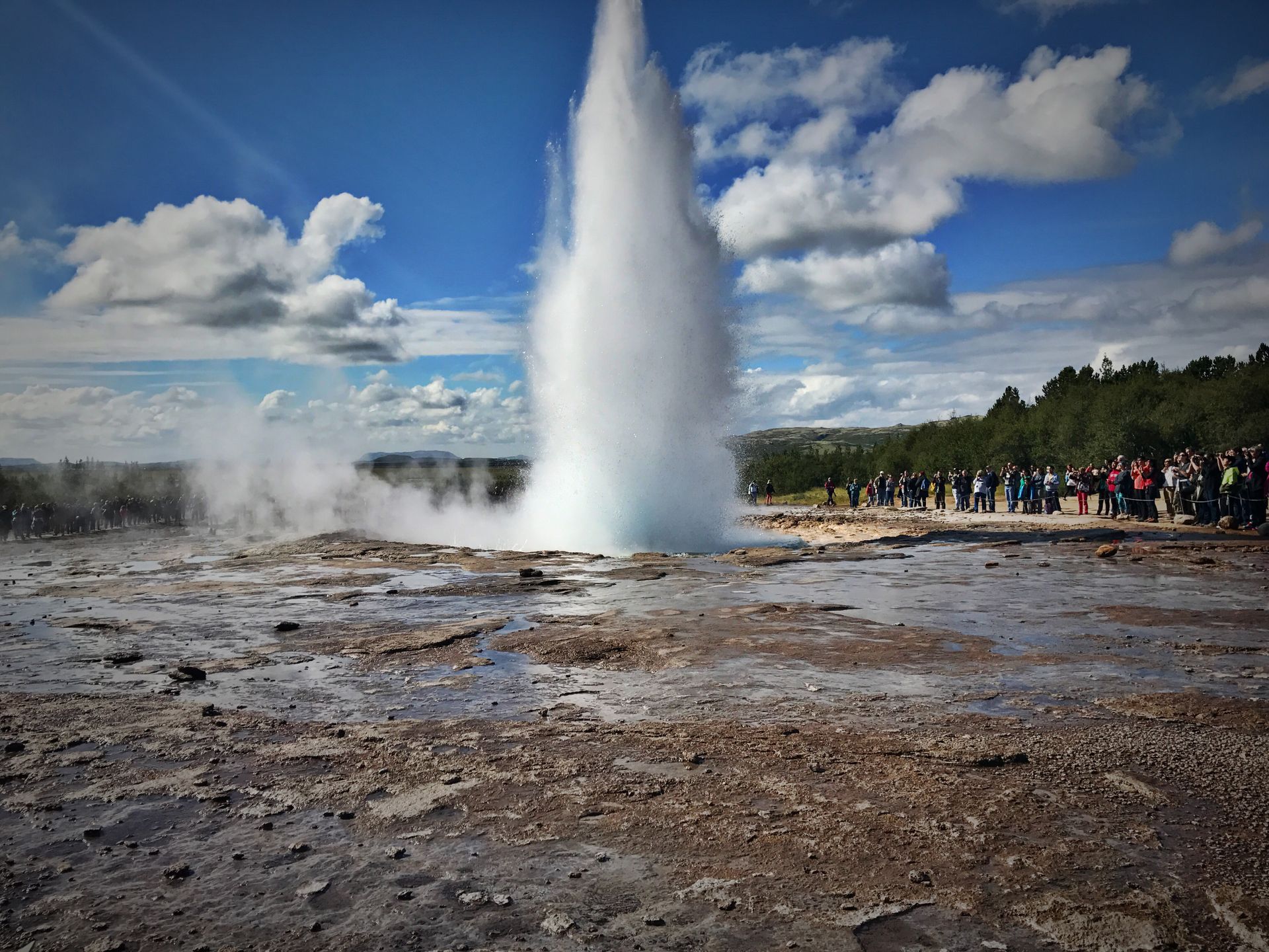 A Strokkur gejzír kitörése forró vízoszloppal Izland geotermikus területén.